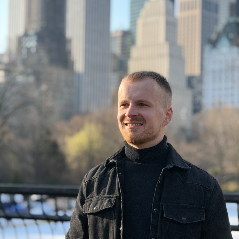 Virgil Bukevičius, smiling in front of a city skyline